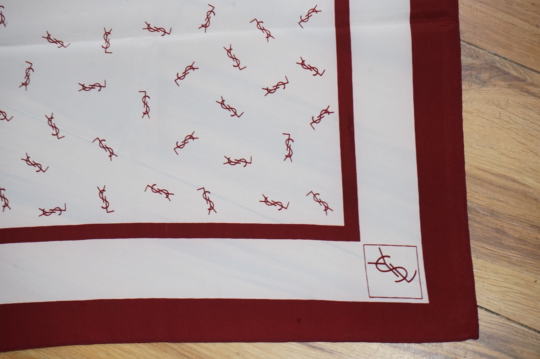 Two Yves Saint Laurent silk scarves comprising a monogrammed example and a patterned brown example with Foulards folding case